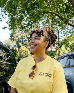 Volunteer smiling outdoors during coast cleanup