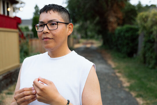 Candid outdoor portrait of thoughtful person in white shirt