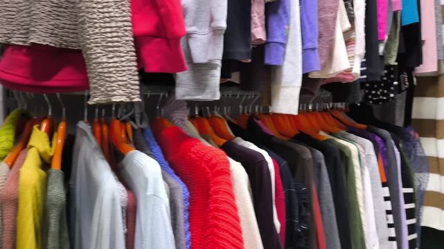Browsing clothes in thrift Shop. Camera moving along rack	
