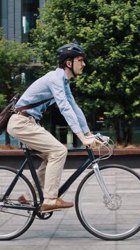Man rides bicycle across quiet urban plaza near offices