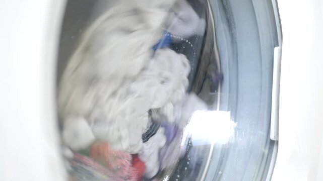 Shooting with a Laundry Machine Washing, Spinning, and Rotating Wet Clothes. Modern Technology Used in Housework for Washing Clothes. 