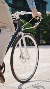 Man pedals bicycle across paved plaza in city close view