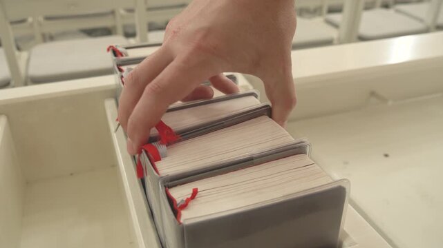 Hand Reaching for Hymn Book in Church