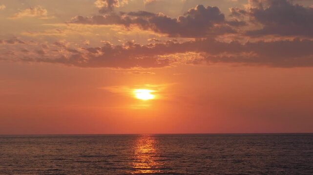 Beautiful Landscape with a Red Sunset in the Middle of the Sea at Dusk. Summer Tropical Sea Sunset View with Clouds on the Sky. Beautiful Red Sunset on the Ocean Landscape.