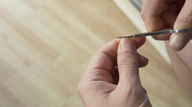 Person Cutting Natural Fingernail with Metal Scissors
