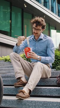Office man eats lunch near parked bicycle after city commute