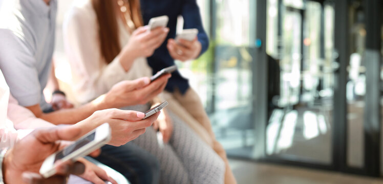 Group of students watching smartphones. Young people addiction to new technology trends.