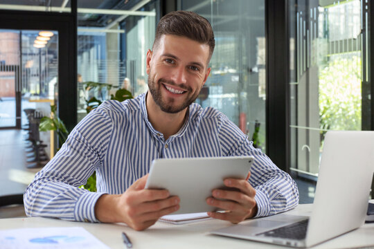 Happy young business man is analizing financial documents  in office