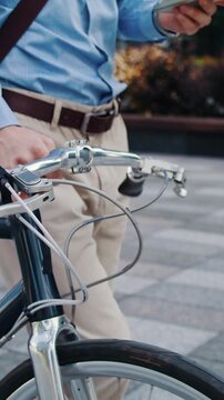 Man checks phone above bicycle handlebars during commute