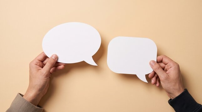Two people holding blank speech bubbles, representing communication, conversation, dialogue, and ideas