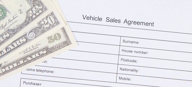 Vehicle sales agreement and dollar banknotes. Sales, purchases new or used vehicle