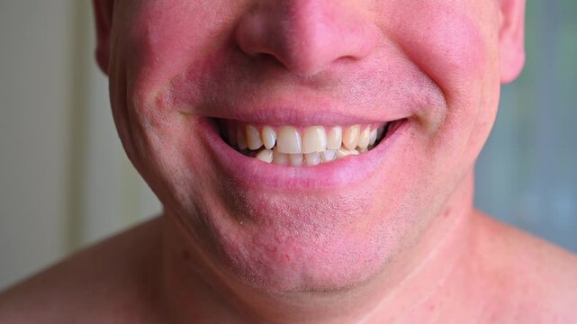 Close-up portrait of a man changing from a neutral expression to a broad toothy smile