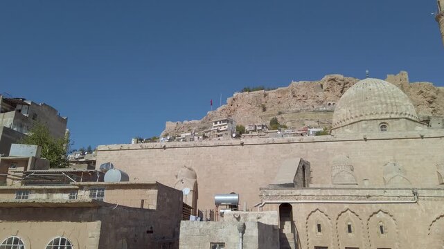 Ulu Cami dome, minaret and stone wall in Mardin, Turkey, the Great Mosque of Mardin below the rocky citadel hill of the old town