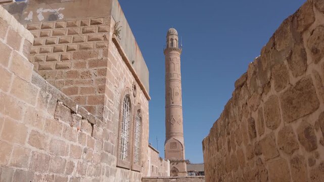 Ulu Cami minaret, Great Mosque of Mardin, Turkey, seen from a narrow alley between the old cut-stone walls of the historic town