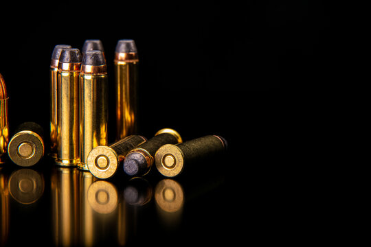 Revolver cartridges and bullets on a black back