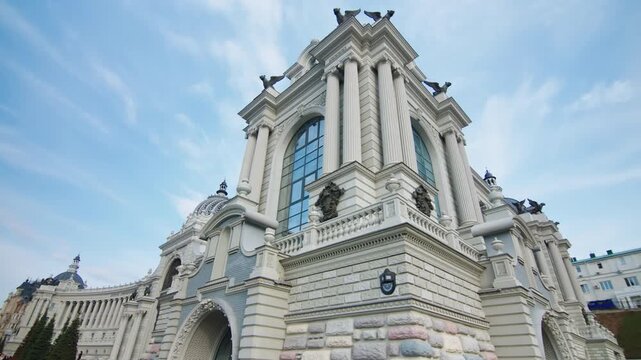 Monumental palace features fine arch windows and carved pillars. Impressive city landmark offers stunning sight for tourists and locals