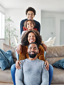 Portrait of a happy black family mother father and kids at home on couch