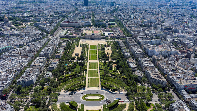 View of the Champ de Mars park, long green lawns, tree-lined paths, and historic urban architecture, Paris, Ile-de-France, France.