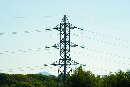 View of an electricity transmission tower standing against a clear sky with the Massif de l'Esterel in the background in Frejus, Provence-Alpes-Cote d'Azur, France.