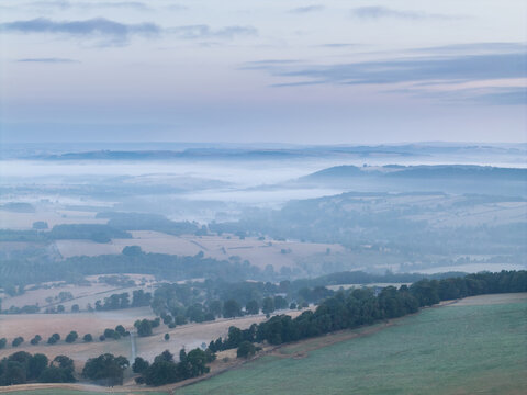 Beautiful drone landscape image over Stanton Moor in Summer Heather sunrise
