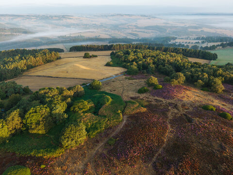 Beautiful drone landscape image over Stanton Moor in Summer Heather sunrise