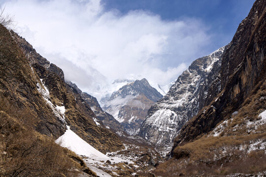 Avalanche snow in narrow Modi Khola valley under clouds