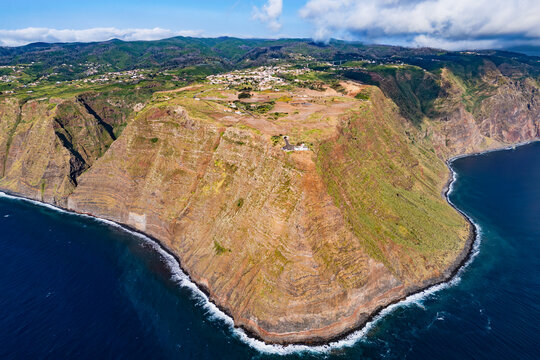 Steep coastal cliffs and lighthouse at Ponta do Pargo on Madeira Island, Atlantic Ocean coastline, drone view