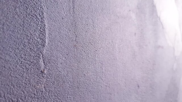 A plastered wall. Gray, rough, grunge-style plaster the surface of a wall inside a room a background.