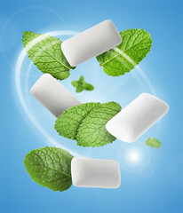 Menthol chewing gum pieces and mint leaves in air against blue background © New Africa