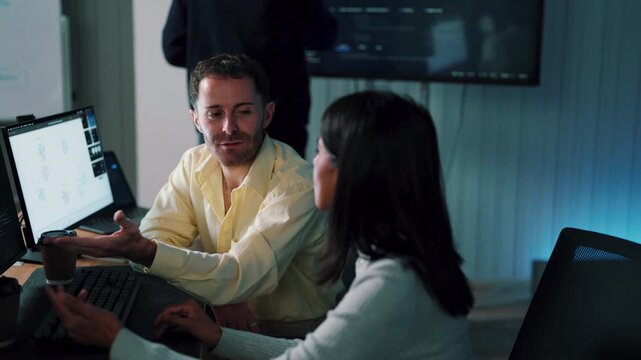 Software developers working together, woman and colleague discussing code at desk in office