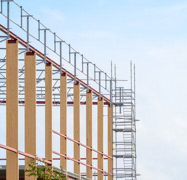 Timber columns and scaffolding forming modern construction framework.