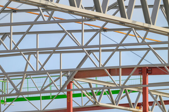 Dense steel truss network at industrial building construction.