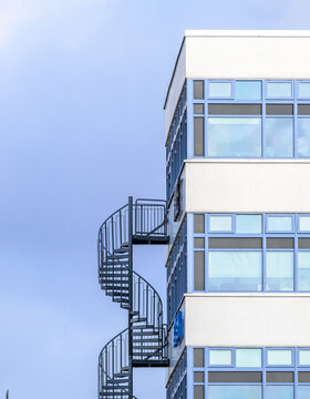 Office building corner with exterior spiral emergency staircase.