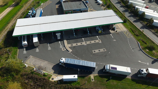 Aerial view of a gas station with heavy goods vehicles queuing and fuelling at the pumps in Rugby, England, United Kingdom.
