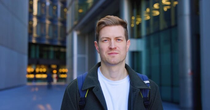 Handsome caucasian man smiling at camera in urban setting