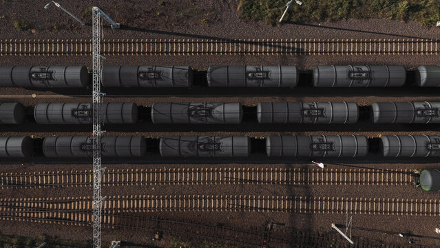 Aerial view of oil tank cars on parallel railway tracks with gravel ballast and overhead power lines in Germany.