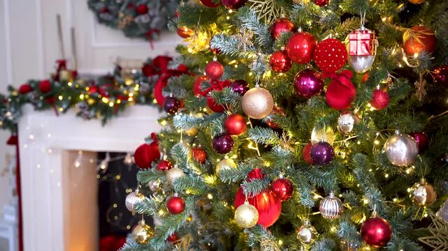 A close-up view of a Christmas tree densely decorated with red and gold baubles, purple ornaments, and warm string lights near a fireplace. Festive, traditional, holiday, winter