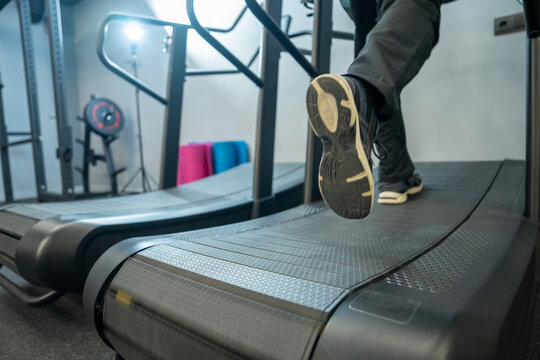 A muscular man is running on a treadmill.