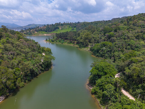 Aerial view of a lake through a dense green forest landscape in Brazil.