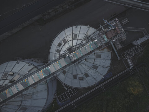 Aerial view of industrial storage silos and connecting conveyor bridge at a facility in Haninge, Stockholm County, Sweden.