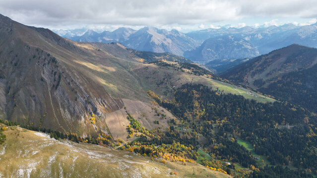 Aerial view of Pointe d'Uble surrounded by autumn forests, rugged mountain slopes, and deep valleys in Taninges, Auvergne-Rhone-Alpes, France.