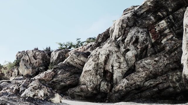 A dramatic rocky terrain showcases immense boulders against a clear blue sky. Nature flourishes around the stones, creating a serene yet powerful scene of strength and stability.