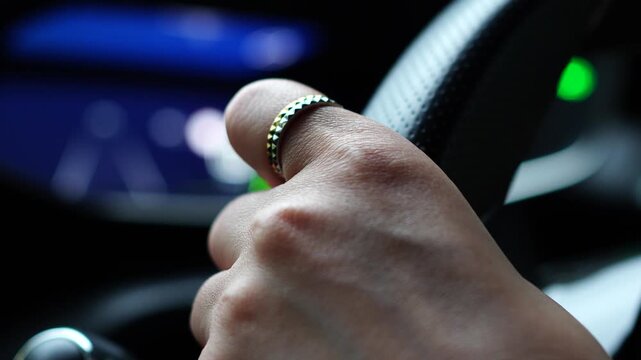 Close-up of a Driver's Hands Holding the Steering Wheel while Driving