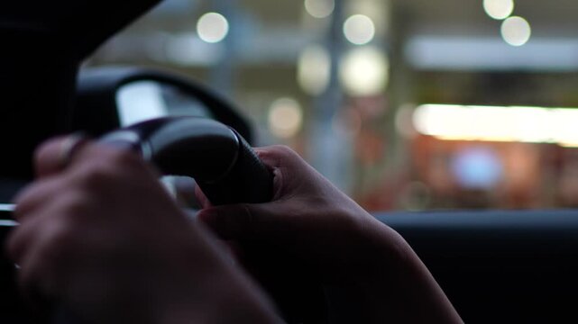 Close-up of a Driver's Hands Holding the Steering Wheel while Driving