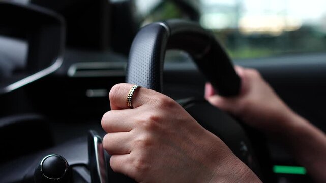 Close-up of a Driver's Hands Holding the Steering Wheel while Driving