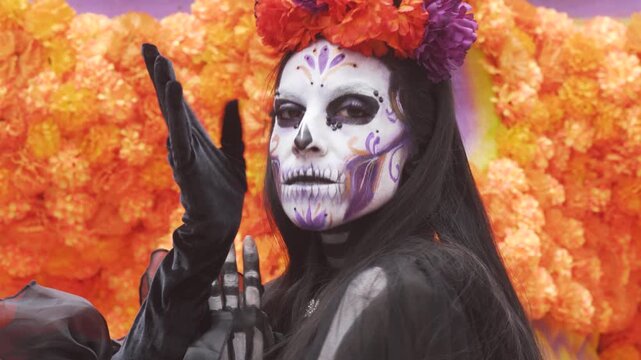 Catrina posing with black fabric before giant marigold skull