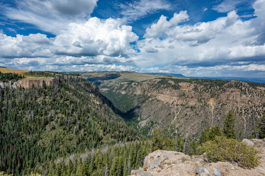 Elevated view of Deep Creek and surrounding mountains from Deep Creek Overlook in Colorado Flat Tops Wilderness under sunny summer cloudscape.