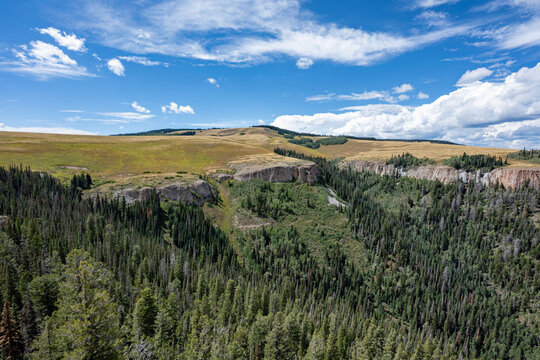 Elevated view of Deep Creek and surrounding mountains from Deep Creek Overlook in Colorado Flat Tops Wilderness under sunny summer cloudscape.