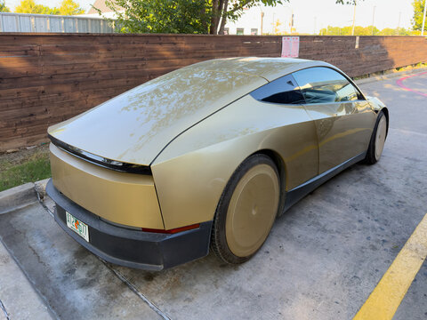 Dallas, Texas, USA - October 15th, 2026: Gold Tesla Cybercab prototype parked in parking lot near Service Entrance outside Tesla service center