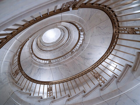 Washington, D.C., USA: Spiral marble staircase with ornate bronze railings inside the U.S. Supreme Court Building, viewed from directly above.